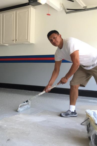 REGI team member applying a garage floor coating